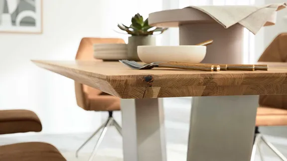 Nahaufnahme der massiven Holz-Tischkante auf Metallgestell, gedeckt mit Schale und Besteck.